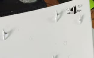 PS5 в руках игрока: съёмные панели, чёрный DualSense, подставка и русский интерфейс