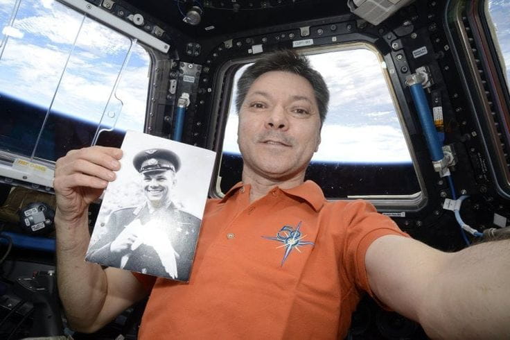 Российский космонавт Олег Кононенко держит в руках фотографию первого человека, совершившего полет в космос — Юрия Гагарина