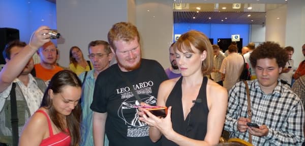 посетители выстроились в очередь к Анне, отдавая свои телефоны на прошивку обновленной системы посетители выстроились в очередь к Анне, отдавая свои телефоны на прошивку обновленной системы