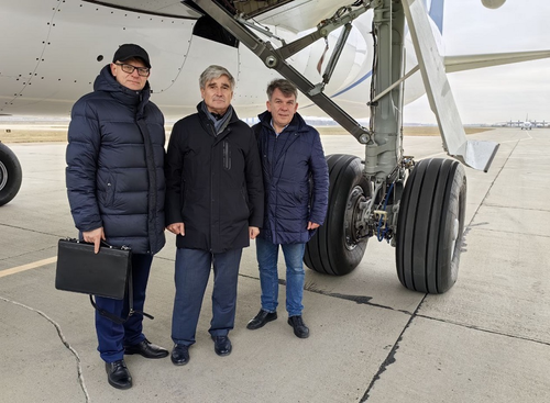 MC-21 Chief Designer Vitaly Naryshkin (center) and employees of NAO Gidromash beside an MC-21 strut at the airfield of the Irkutsk Aviation Plant