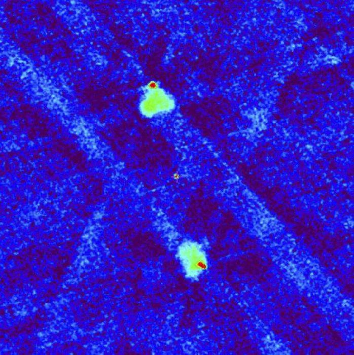 Радиоизображение квазара по данным обзора VLASS на частоте 3 ГГц (размер кадра 6.5 угловых минут). Крест в центре обозначает положение оптического источника. Верхняя и нижняя красные точки соответствуют «горячим» пятнам (областям торможения джетов) в протяженных «радиоушах», показанных зеленым цветом