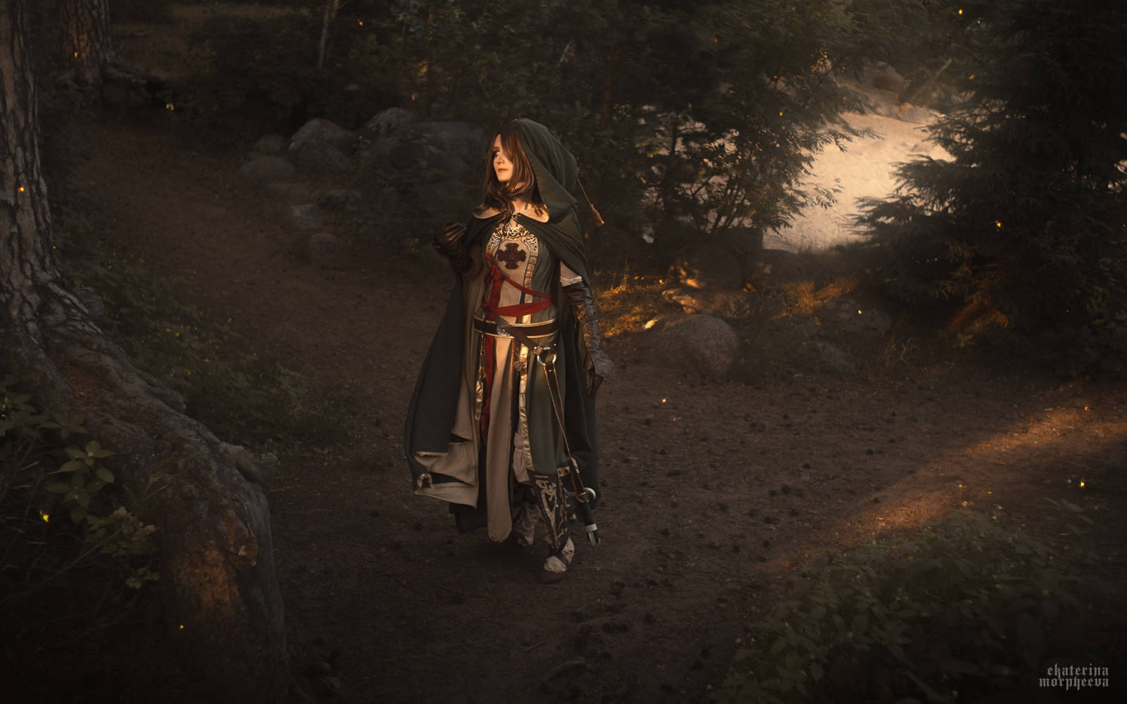 Reganight as Emerald Herald, posing with her hood up, shrouded in green fabric