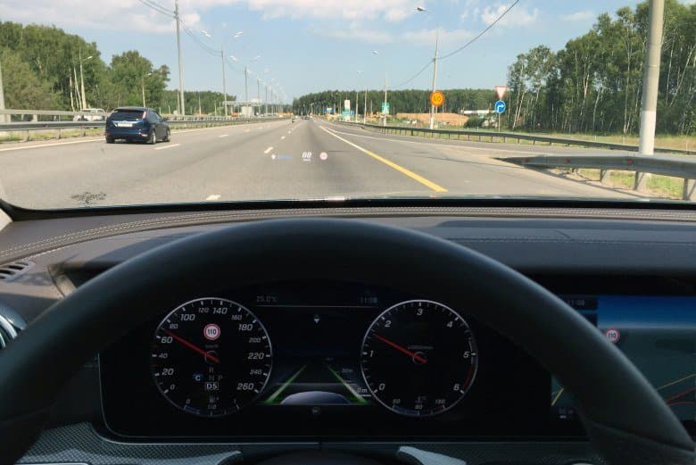 Системой принято ограничение скорости 110 км/ч. Видна индикация принятого ограничения на приборной панели, прекционном дисплее и дисплее Comand Online. Впереди виден временный знак, ограничивающий скорость до 60км/ч